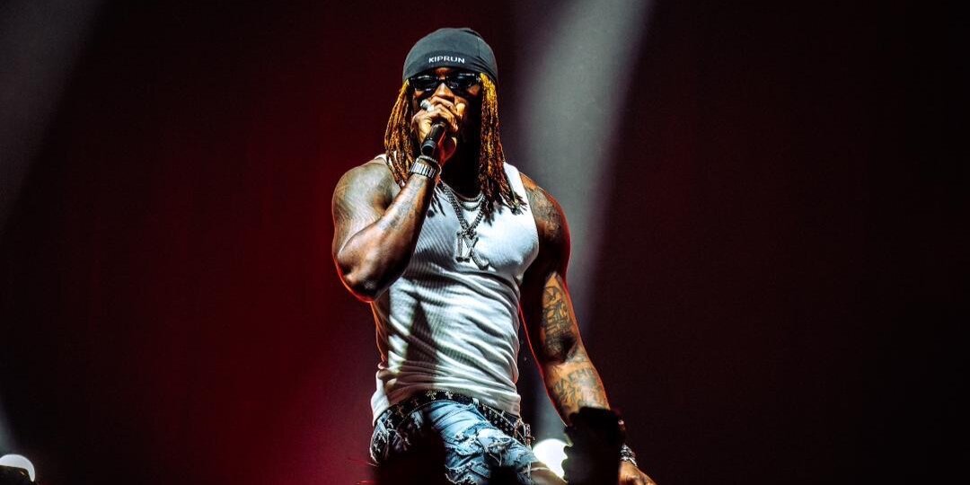 HIMRA rapping on stage in a white tank top